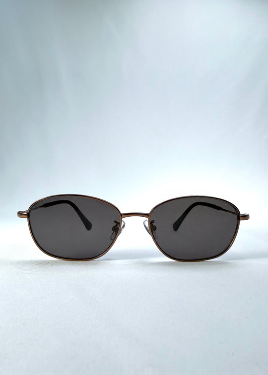 Front view of AZE Selene Line sunglasses in Mocha Alloy, featuring a slim bronze-tone oval metal frame and smoky brown lenses, showing the full front silhouette.