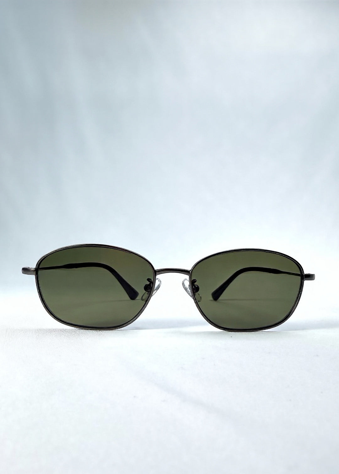 Front view of AZE Selene Line sunglasses in Sage Gunmetal, featuring a slim gunmetal oval metal frame and sage-green lenses, showing the full front silhouette.