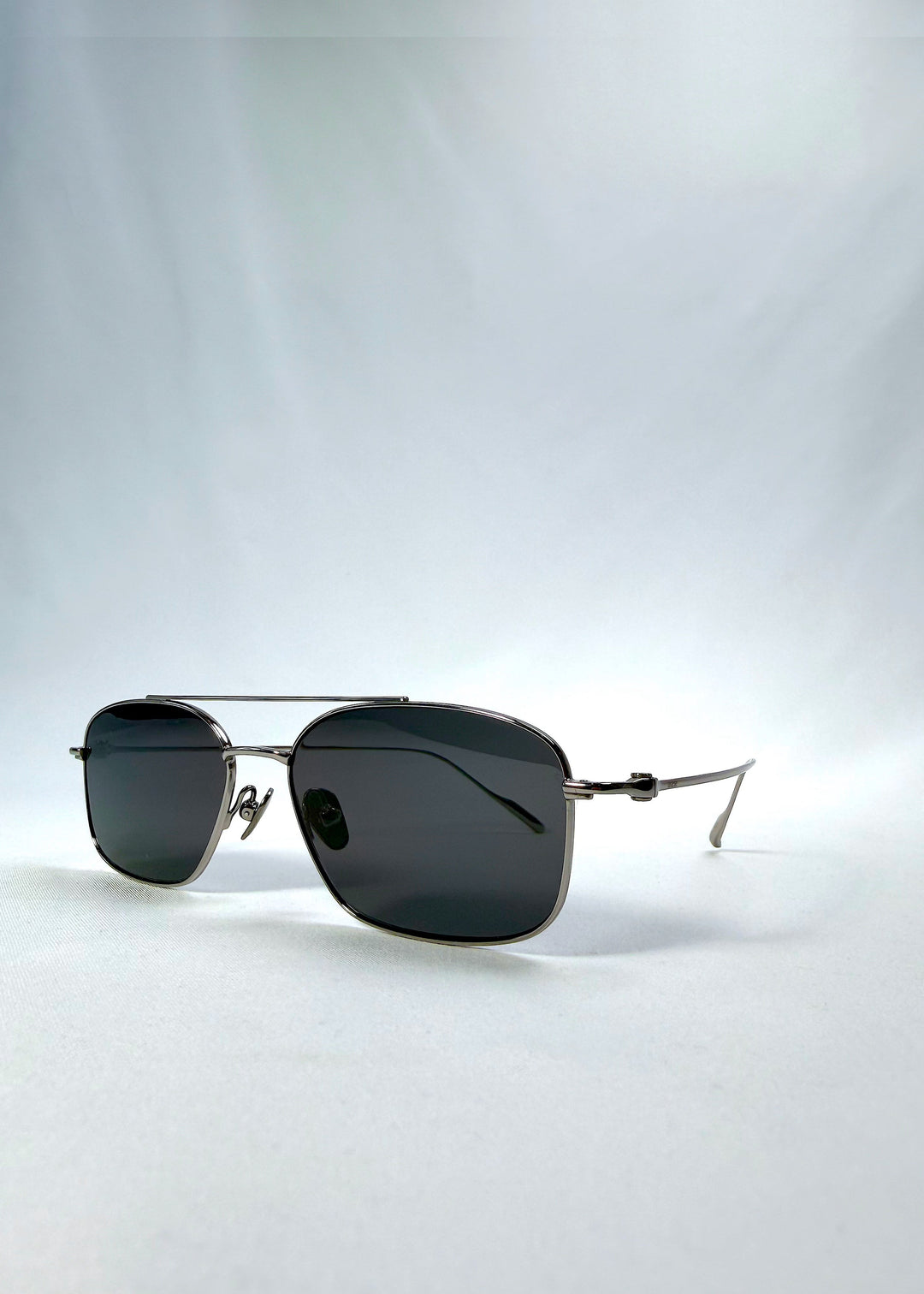 Three-quarter front view of Seren Arc sunglasses in Gunmetal Veil, featuring gunmetal frame and dark tinted lenses, showing the front shape and temple profile. 