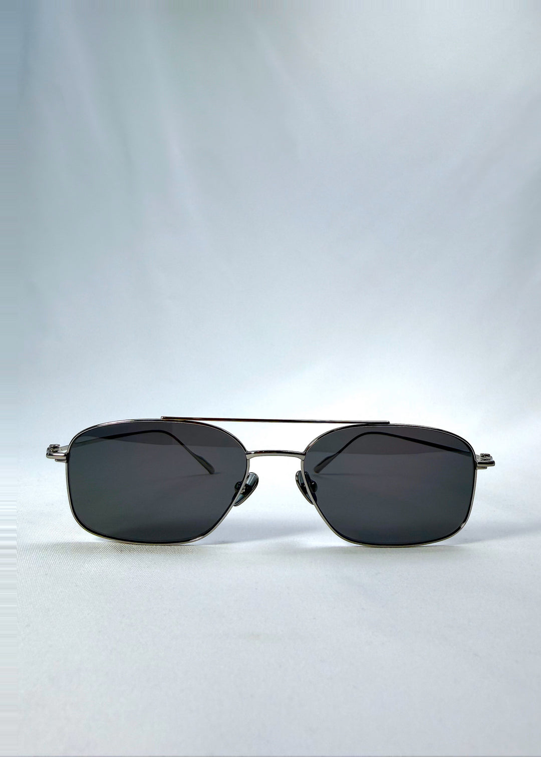 Front view of Seren Arc sunglasses in Gunmetal Veil, featuring gunmetal frame and dark tinted lenses, showing the full front silhouette.