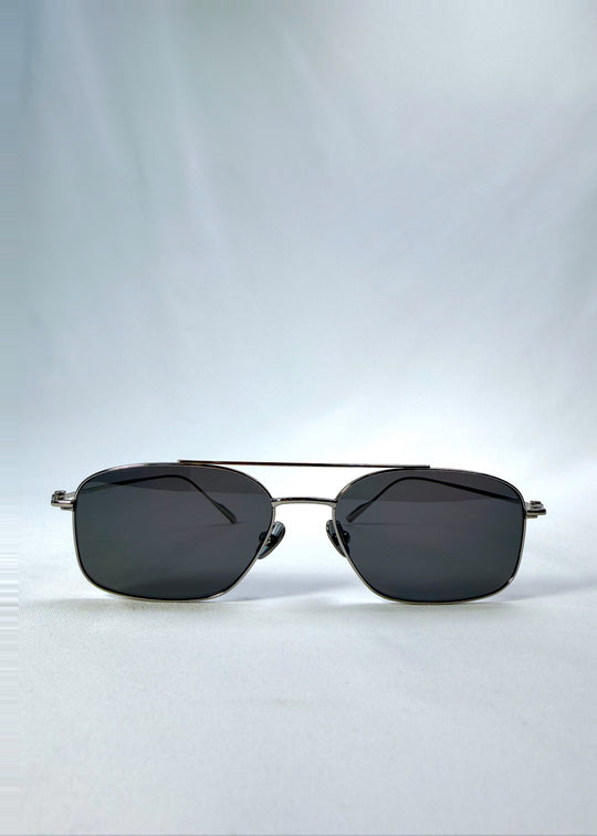 Front view of Seren Arc sunglasses in Gunmetal Veil, featuring gunmetal frame and dark tinted lenses, showing the full front silhouette. 
