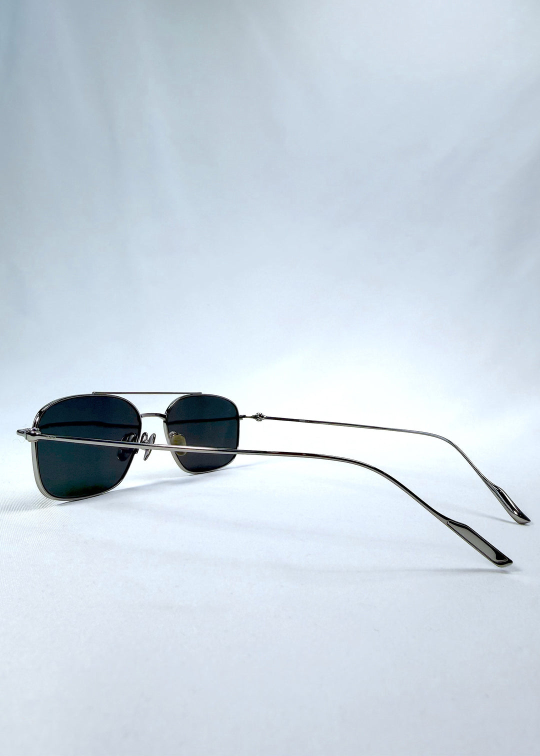 Side-angle view of Seren Arc sunglasses in Gunmetal Veil, featuring gunmetal frame and dark tinted lenses, showing the lens shape and side temple profile. 