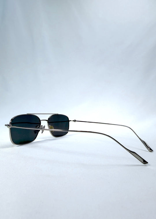 Side-angle view of Seren Arc sunglasses in Gunmetal Veil, featuring gunmetal frame and dark tinted lenses, showing the lens shape and side temple profile. 