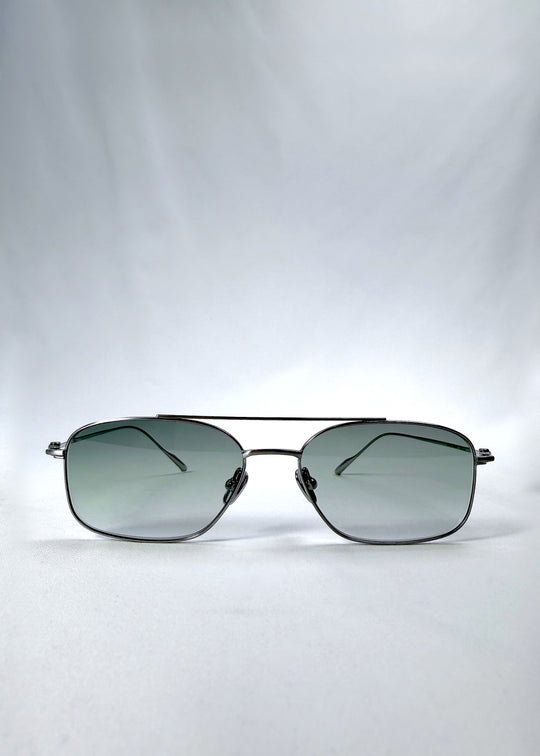 Front view of Seren Arc sunglasses in Moonlit Silver, featuring silver metal frame and pale green lenses, showing the full front silhouette.