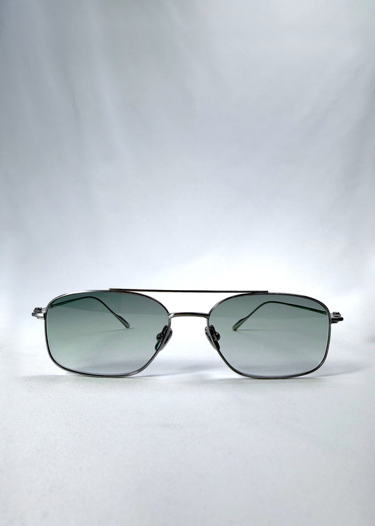 Front view of Seren Arc sunglasses in Moonlit Silver, featuring silver metal frame and pale green lenses, showing the full front silhouette. 