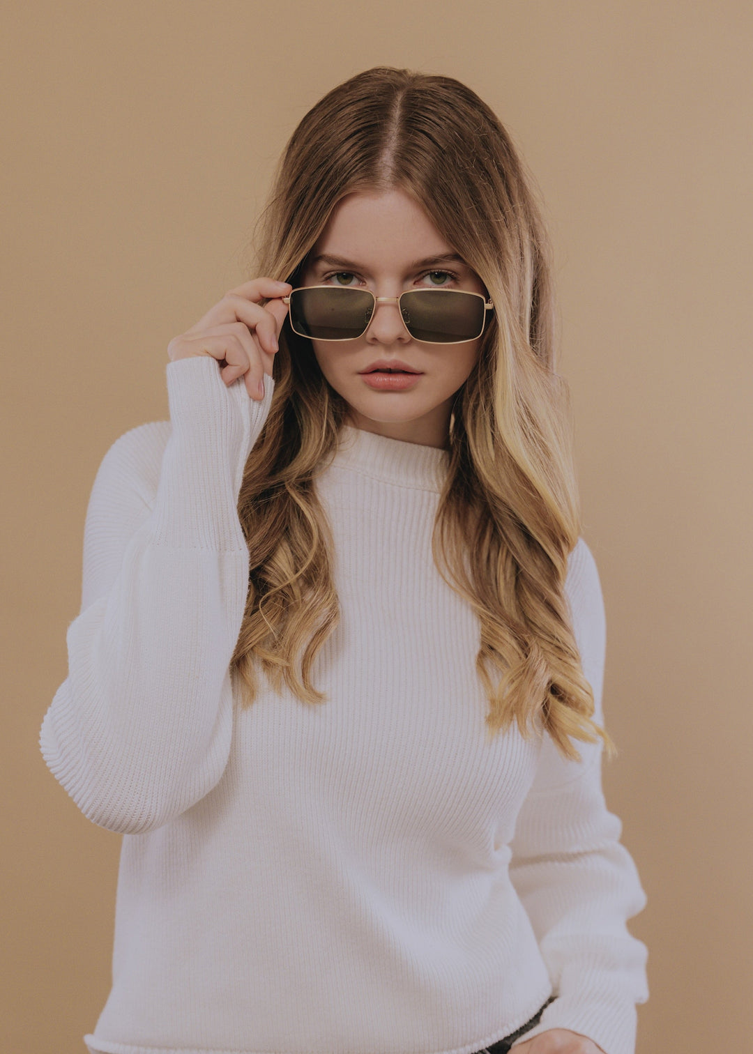 Female model styling Sirius A - Gold prescription sunglasses, showcasing its versatile and timeless design. 