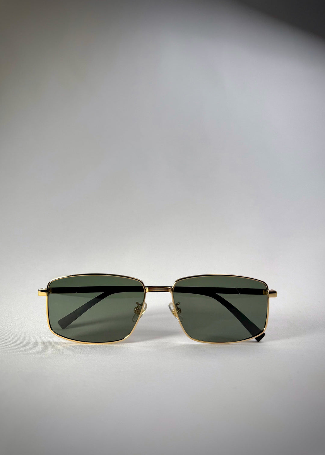 Folded front view of Sirius A - Gold stainless steel sunglasses featuring a sleek gold frame and polarized green lenses for a refined, modern look. 