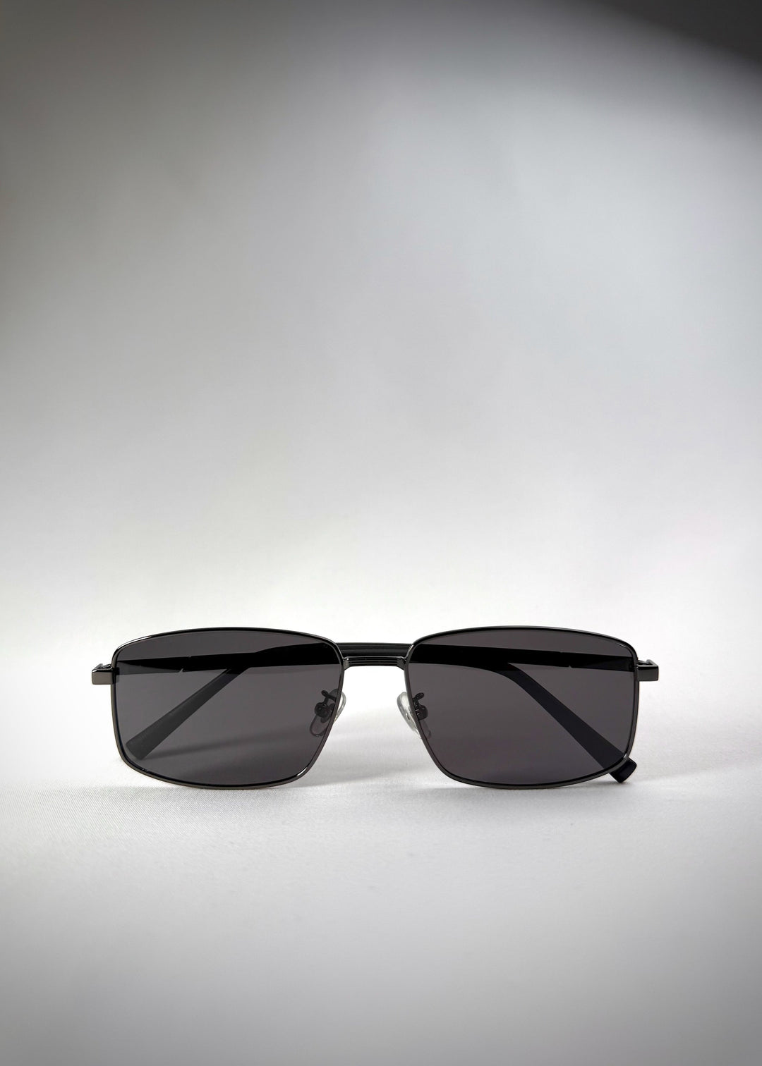 Front view of folded Sirius A - Gunmetal Gray stainless steel sunglasses, featuring a sleek rectangular frame and polarized gray lenses for a sophisticated, modern look. 
