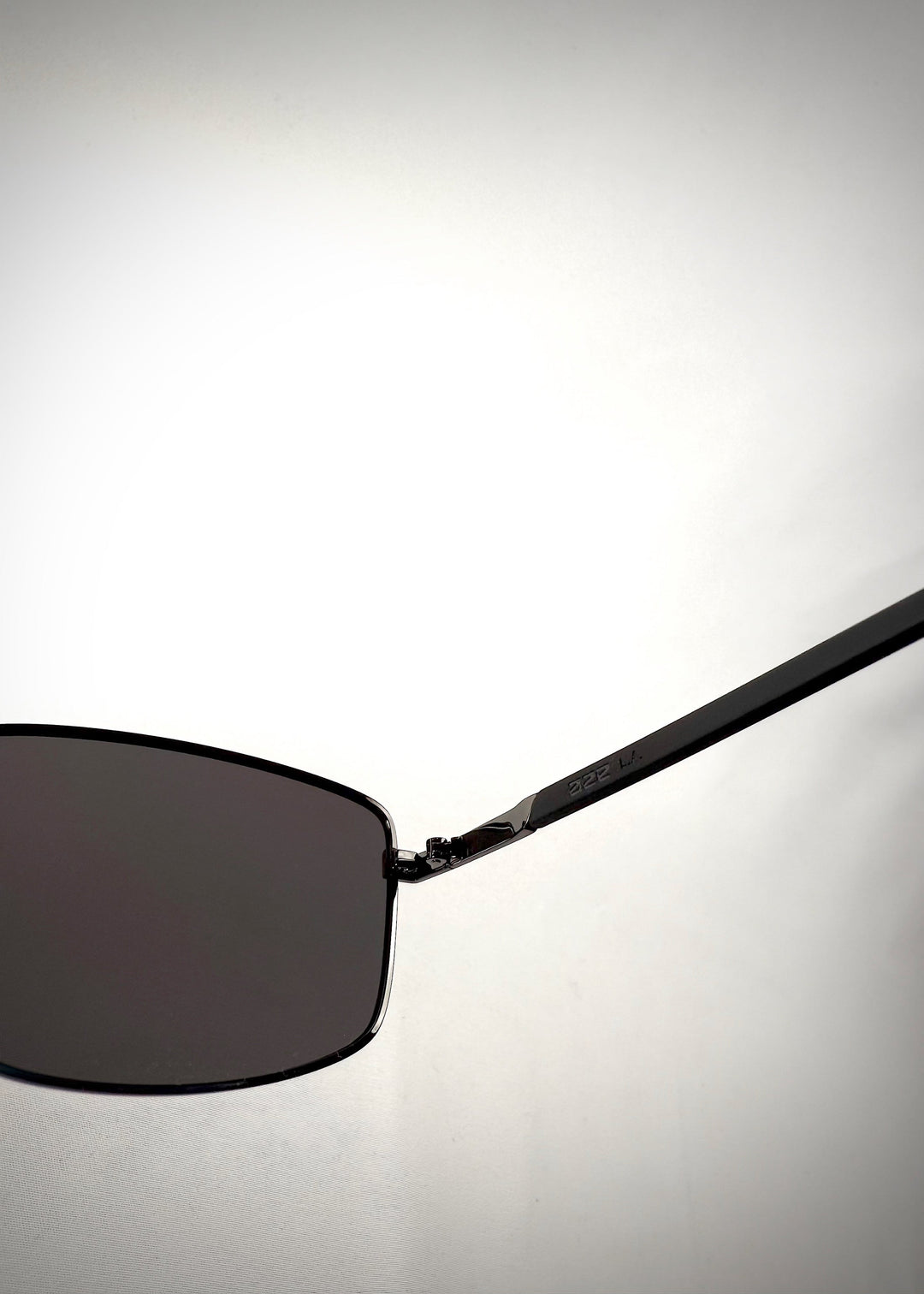 Close-up side view of Sirius A - Gunmetal Gray stainless steel sunglasses, showcasing the sleek metallic temple design with engraved branding and seamless hinge construction. 