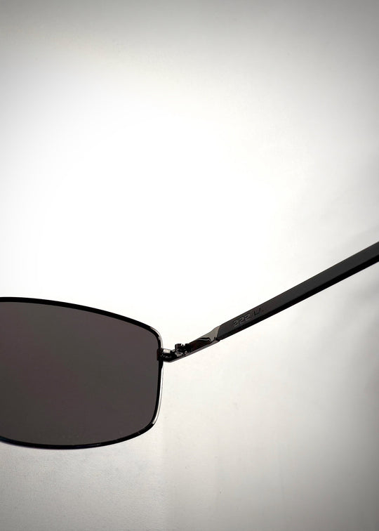 Close-up side view of Sirius A - Gunmetal Gray stainless steel sunglasses, showcasing the sleek metallic temple design with engraved branding and seamless hinge construction. 