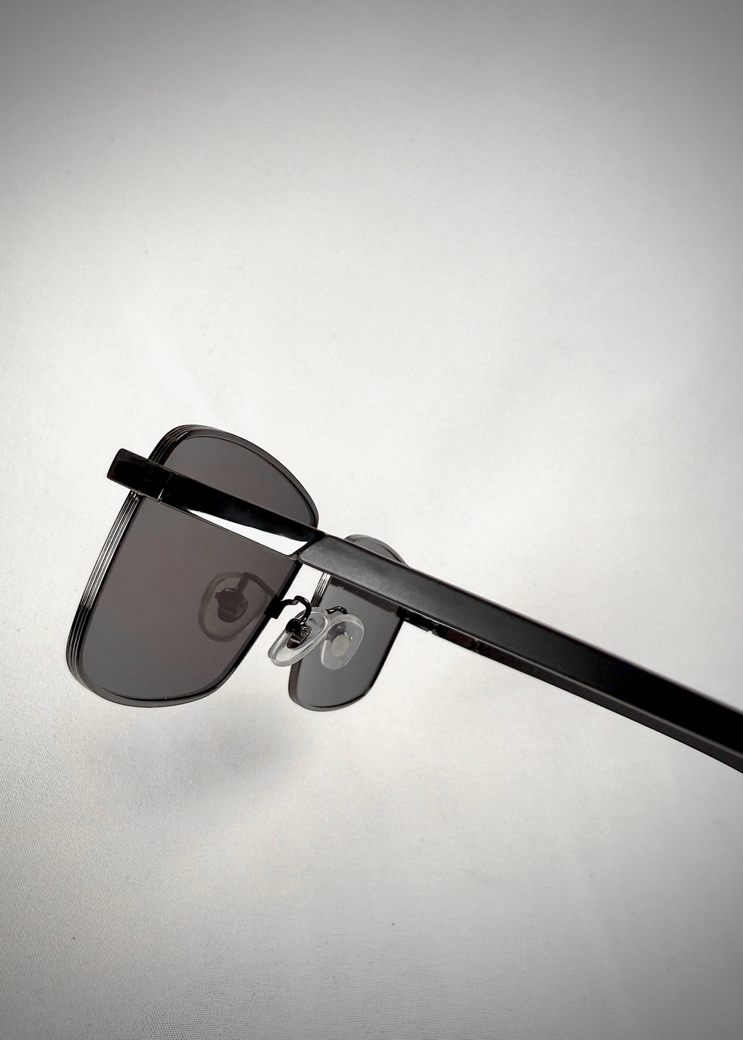 Close-up of Sirius A - Gunmetal Gray sunglasses, highlighting the smooth temple arms and durable frame construction. 