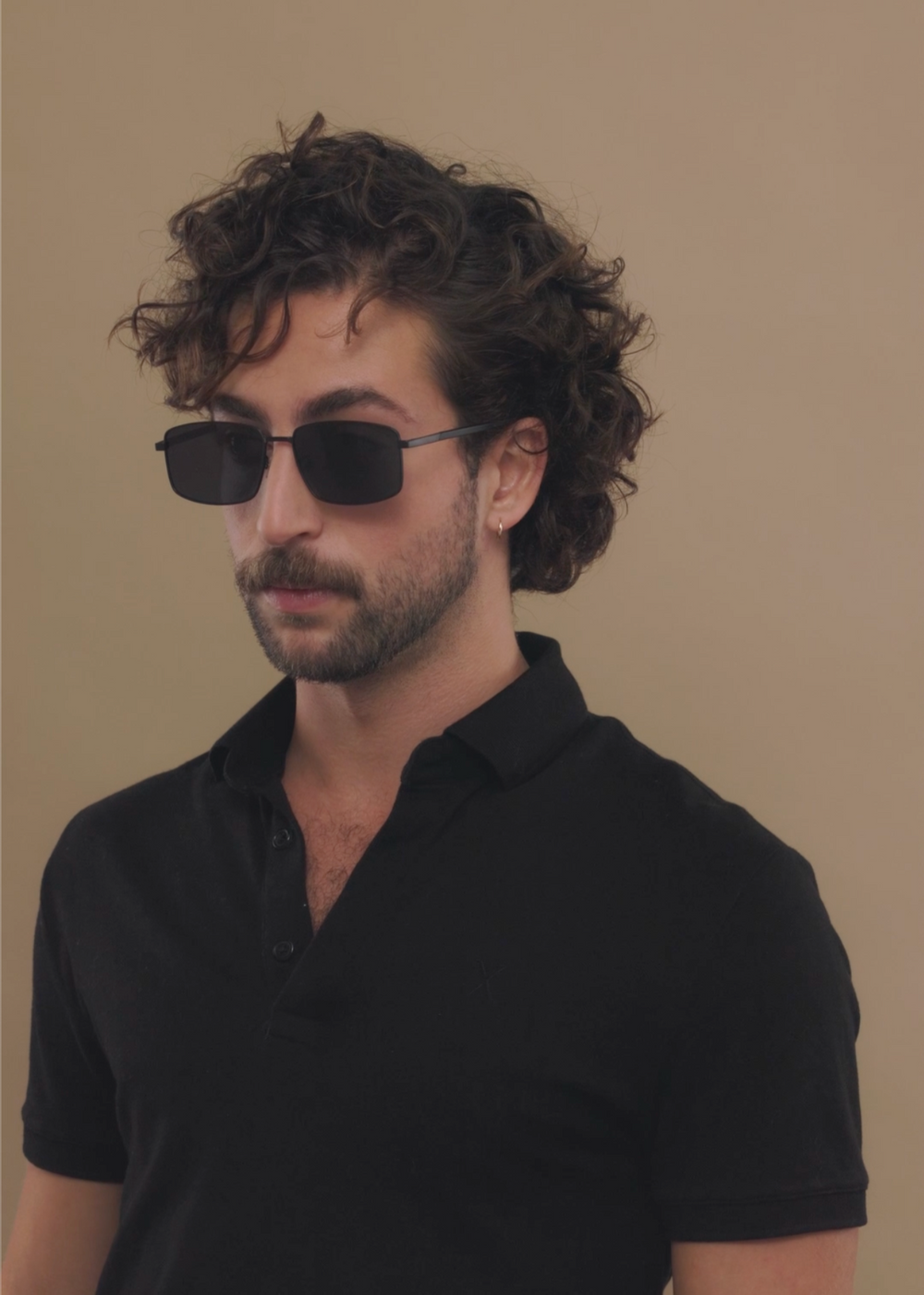 A male model styling Sirius A - Semi-Matte Black sunglasses, demonstrating its timeless and versatile appeal.