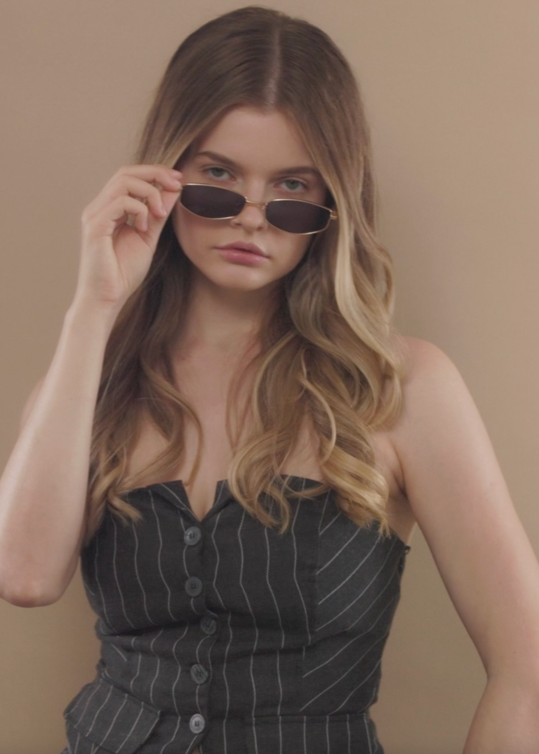 Female model wearing Sirius B - Gold sunglasses, showcasing a chic and timeless aesthetic. 