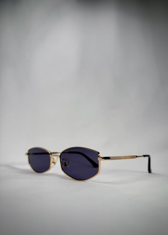 Angled view of Sirius B - Gold stainless steel sunglasses, featuring a lightweight frame and sophisticated blue-gray lenses. 
