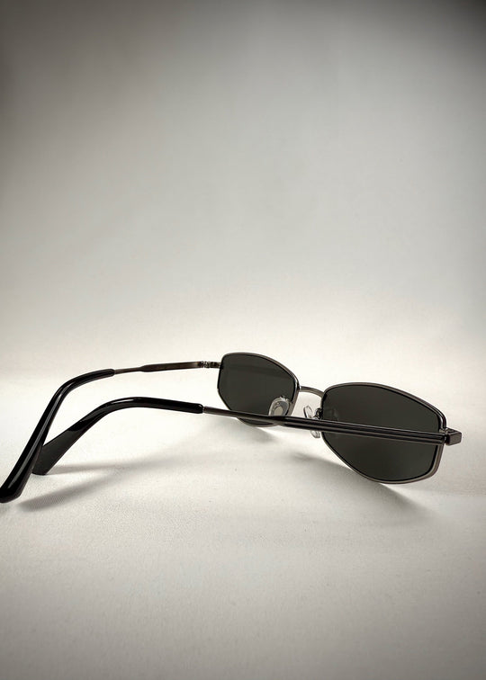 Back-angle view of Sirius B - Matte Black stainless steel sunglasses, highlighting the sleek metal frame, neutral gray lenses, and curved temple arms for a secure fit. 