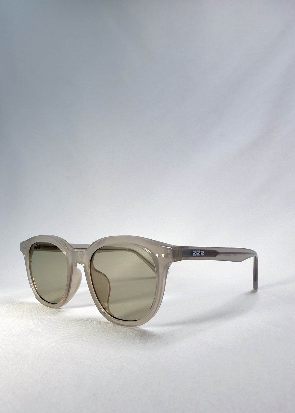 Front-angle view of Elvor sunglasses in Glacier Smoke, showing the round frame shape and temple profile. #color_glacier-smoke
