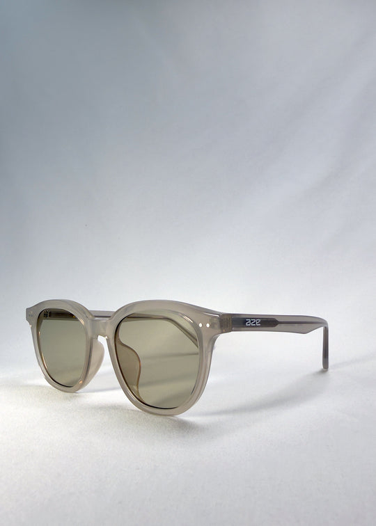 Front-angle view of Elvor sunglasses in Glacier Smoke, showing the round frame shape and temple profile. 