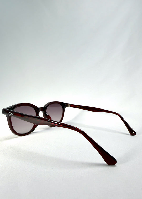 Elvor sunglasses in Mulberry Mist, back-angle view showing the translucent wine-red acetate frame and curved temples. Subtle light reflection highlights the smooth finish. 