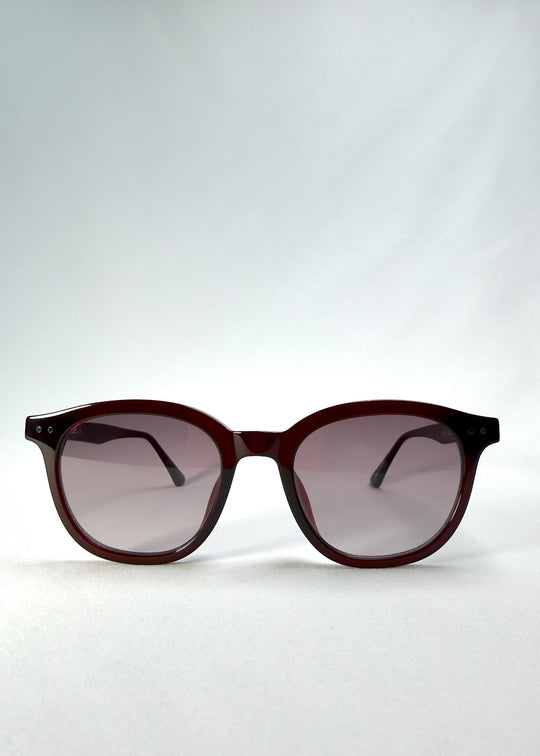 Front view of Elvor sunglasses in Mulberry Mist featuring rounded frames and violet-to-grey gradient lenses for a vintage yet modern style. 
