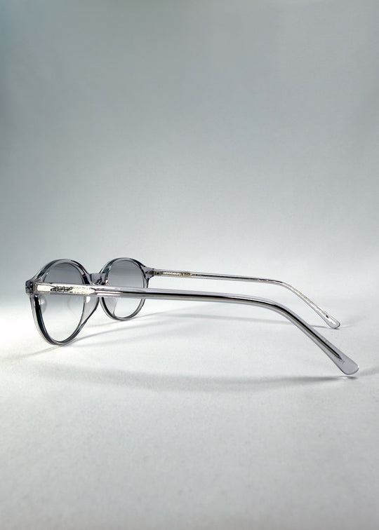 Back-angle view of Glint Softint sunglasses in Crystal Verge showing translucent grey acetate frame and gradient smoke lenses. 