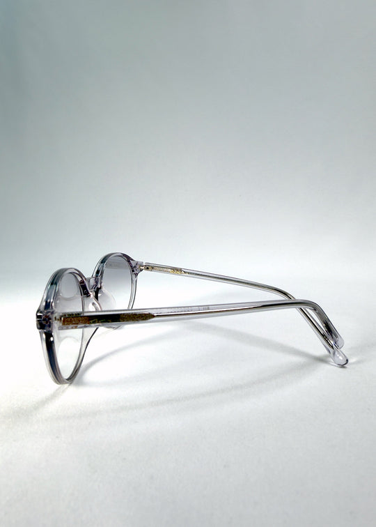 Folded-angle view of Glint Softint sunglasses in Crystal Verge featuring clear grey acetate arms and softly tinted smoke lenses. 
