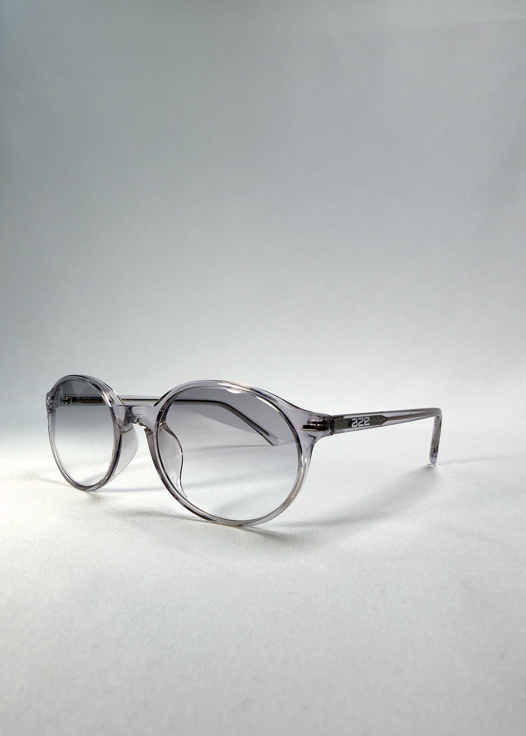 Front-angle view of Glint Softint sunglasses in Crystal Verge highlighting transparent grey frame and softly smoked lenses with UV400 protection. 