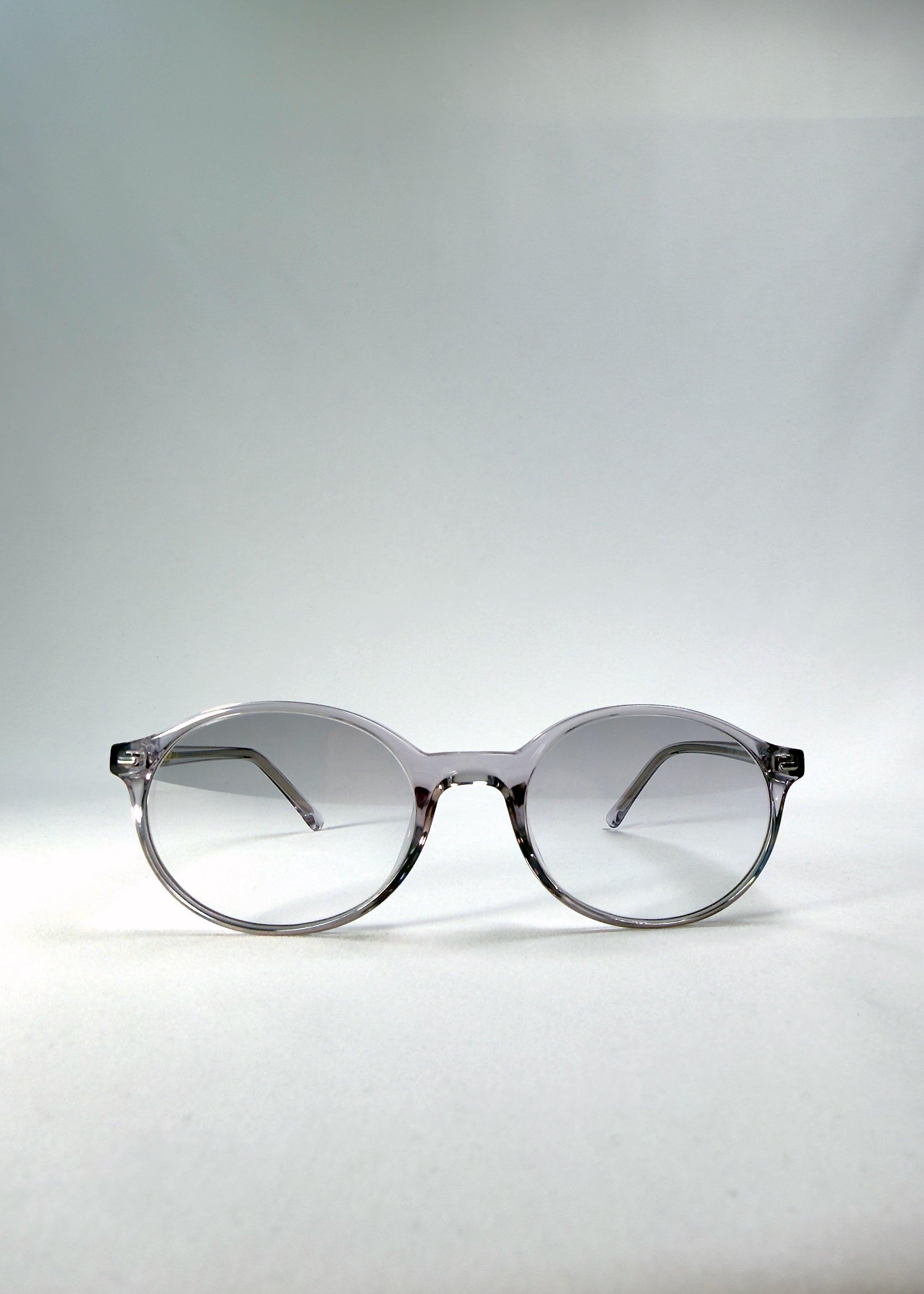 Front view of Glint Softint sunglasses in Crystal Verge featuring clear grey round frame and gradient smoke Softint lenses.