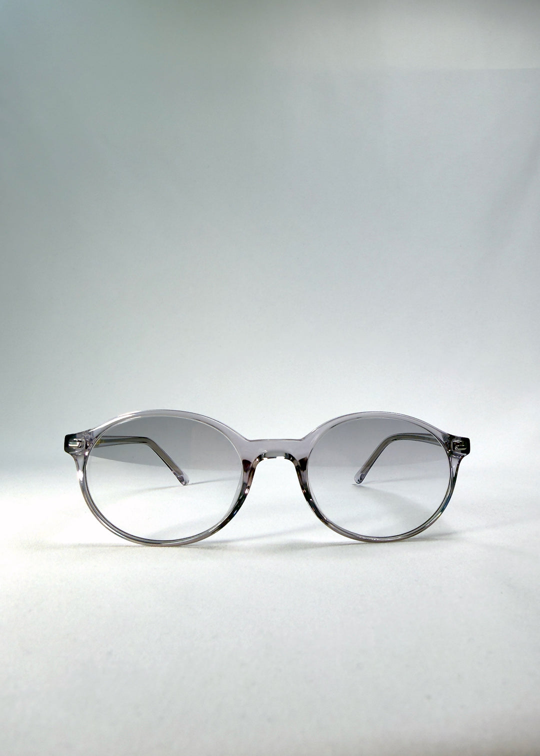 Front view of Glint Softint sunglasses in Crystal Verge featuring clear grey round frame and gradient smoke Softint lenses. 