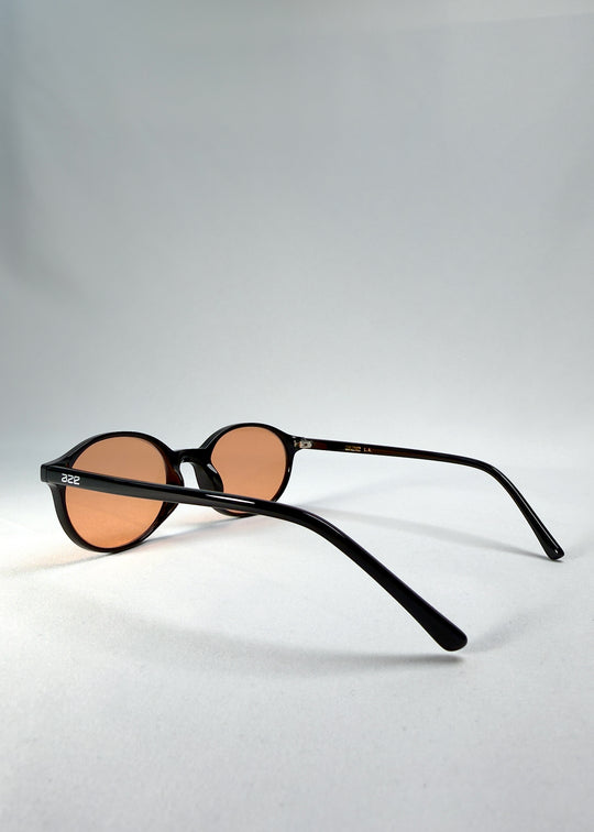 Side-temple view of Glint Softint sunglasses in Obsidian Beam showing the curved acetate arms and smooth hinge finish.