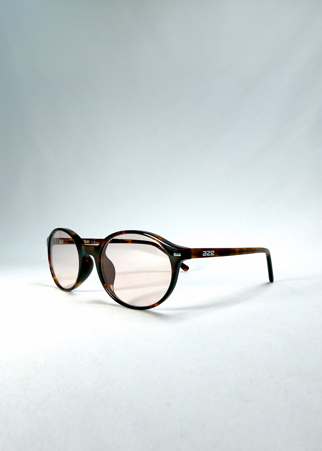 Front-angle view of Glint Softint sunglasses in Umber Ripple highlighting the translucent tortoise frame and rose-tinted lenses. 