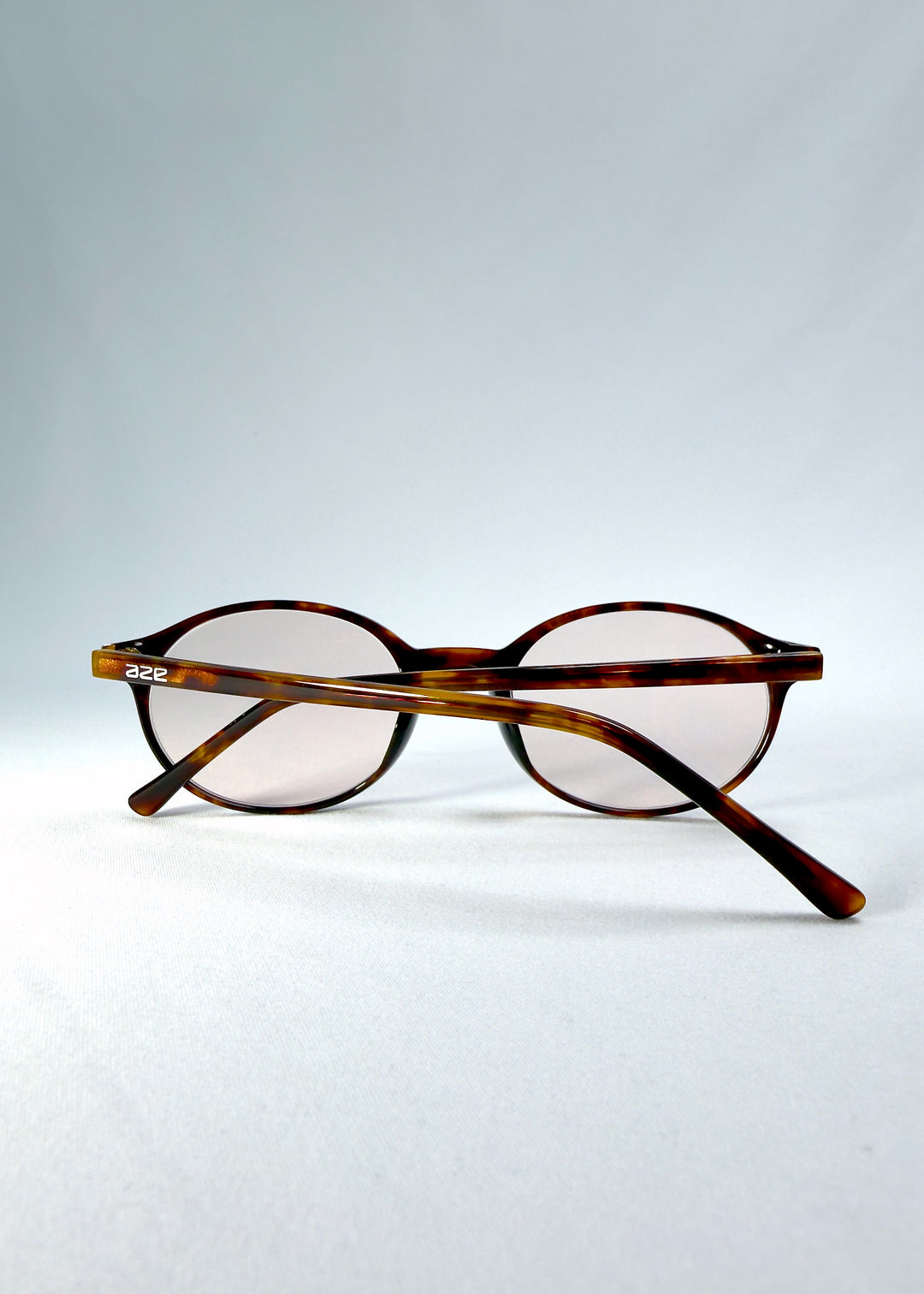 Side-temple view of Glint Softint sunglasses in Umber Ripple showing smooth acetate arms and hinge detail.