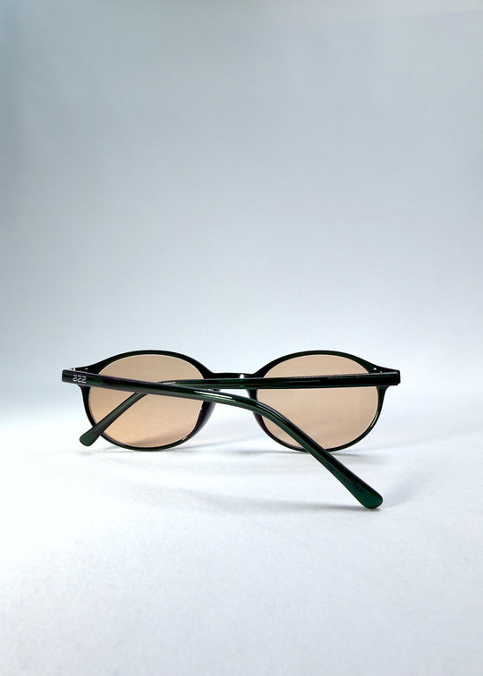 Back-angle view of Glint Softint sunglasses in Verdant Halo showing deep green acetate frame and rose-tinted lenses.