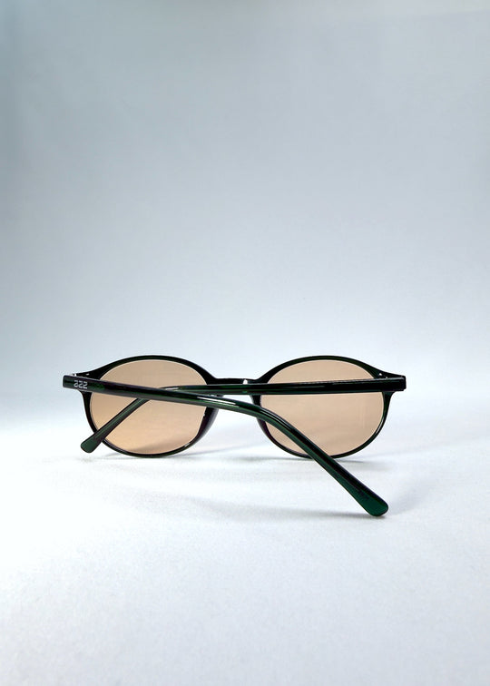 Back-angle view of Glint Softint sunglasses in Verdant Halo showing deep green acetate frame and rose-tinted lenses. 
