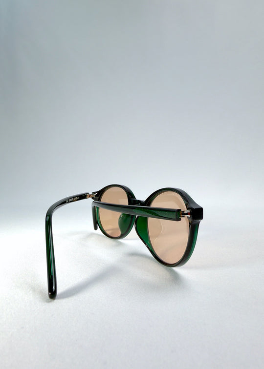 Back view of Glint Softint sunglasses in Verdant Halo showing balanced frame curvature and slim green temples. 