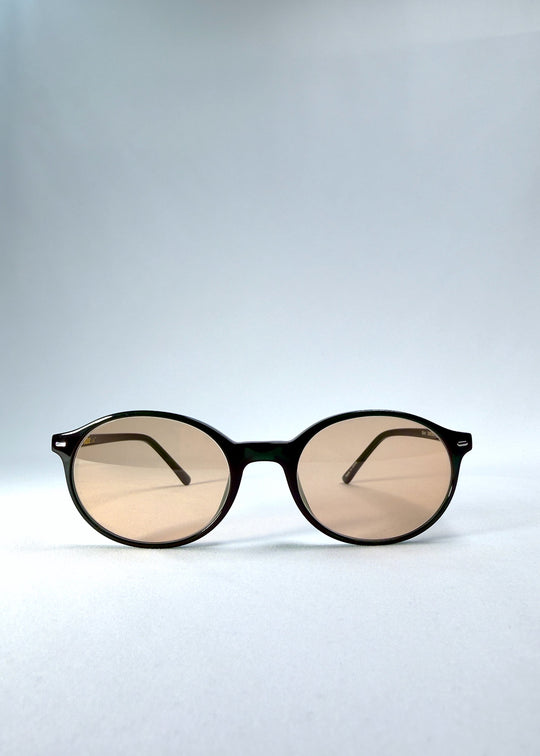 Front view of Glint Softint sunglasses in Verdant Halo featuring rounded green frame and rose-tinted Softint lenses with UV400 protection. 