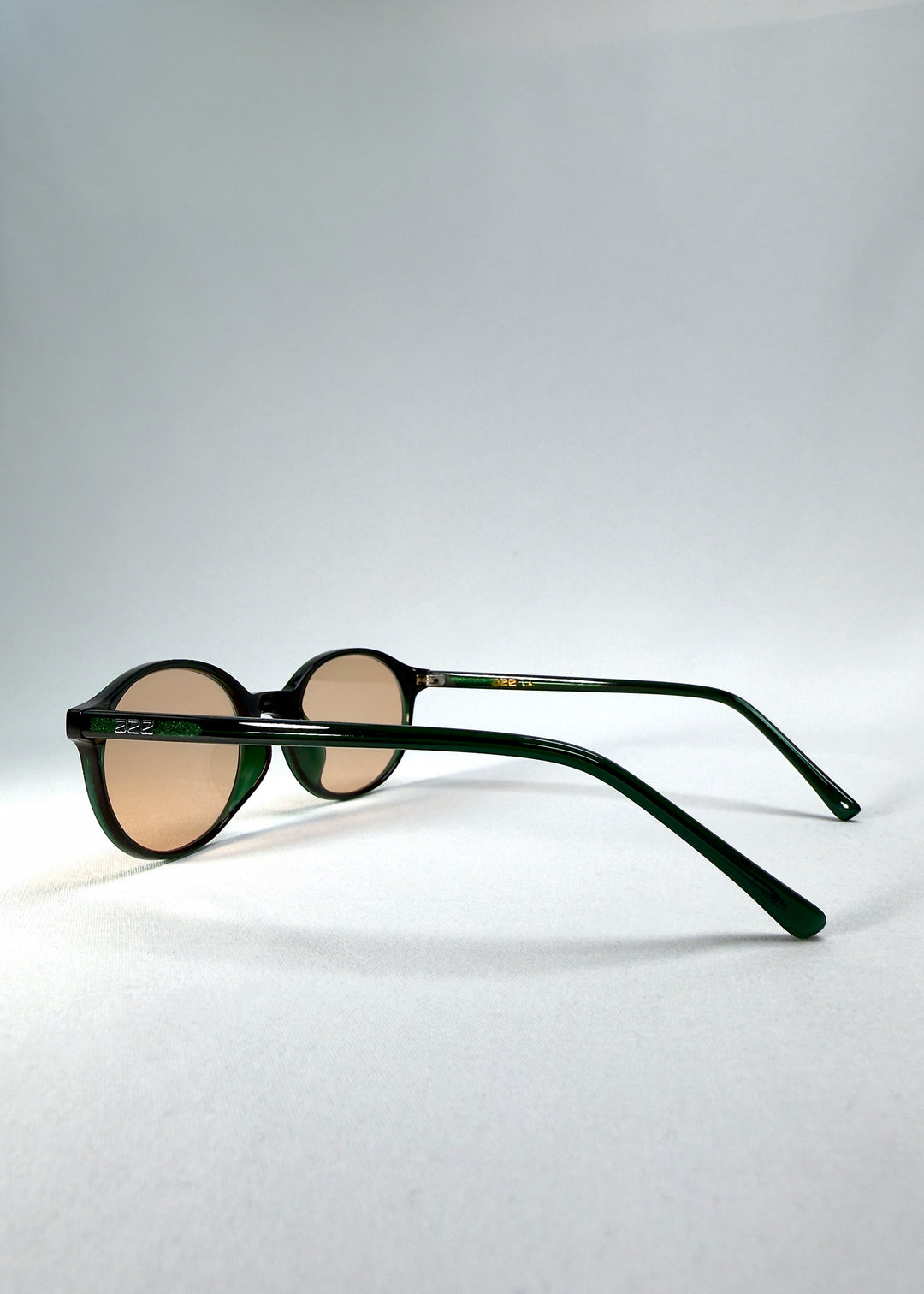 Side-temple view of Glint Softint sunglasses in Verdant Halo showing the smooth acetate arms and hinge detail. 