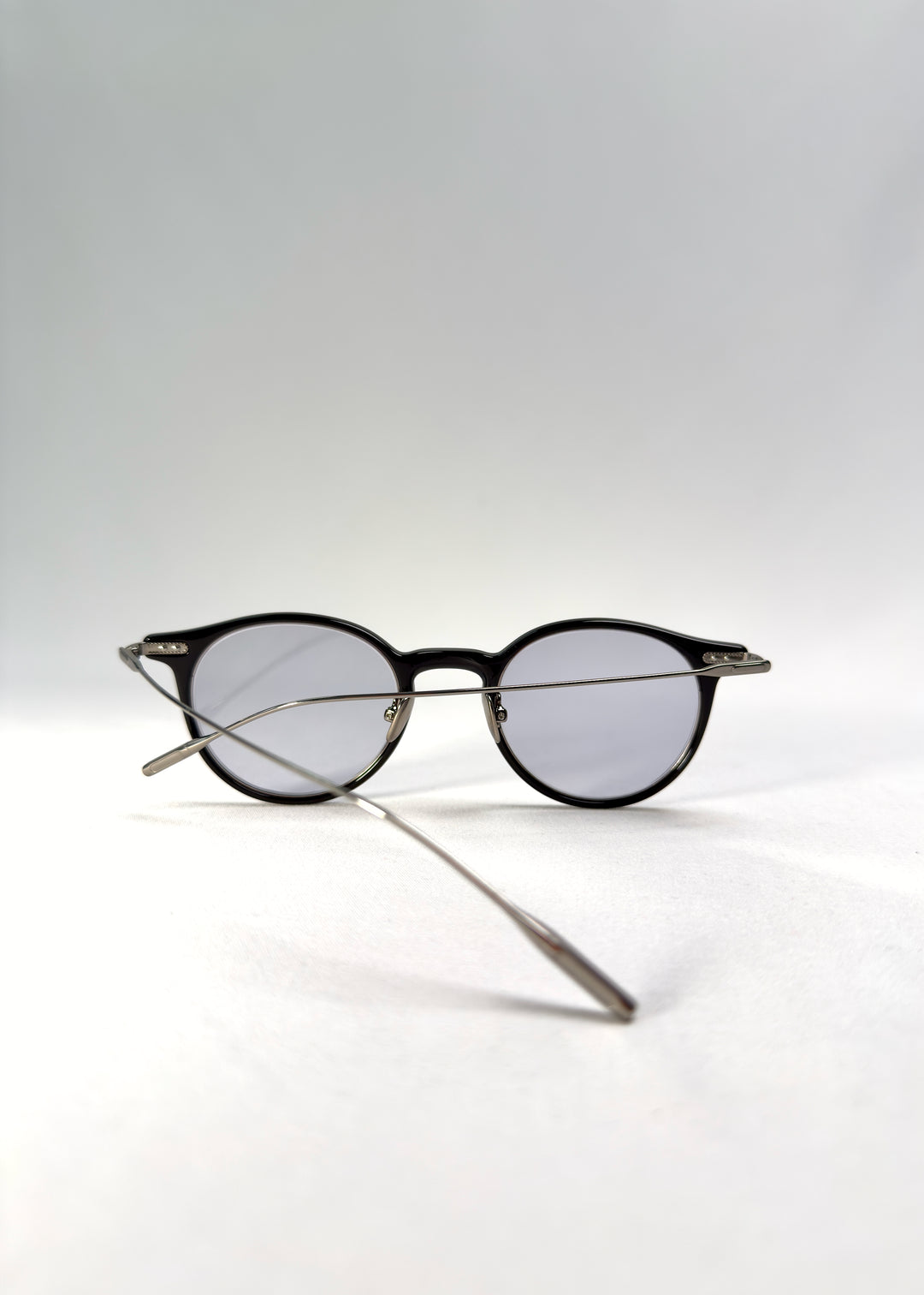 Back-angle view of Lunor Drift Softint sunglasses in Onyx Fade showing the black-to-silver acetate frame and titanium temples.