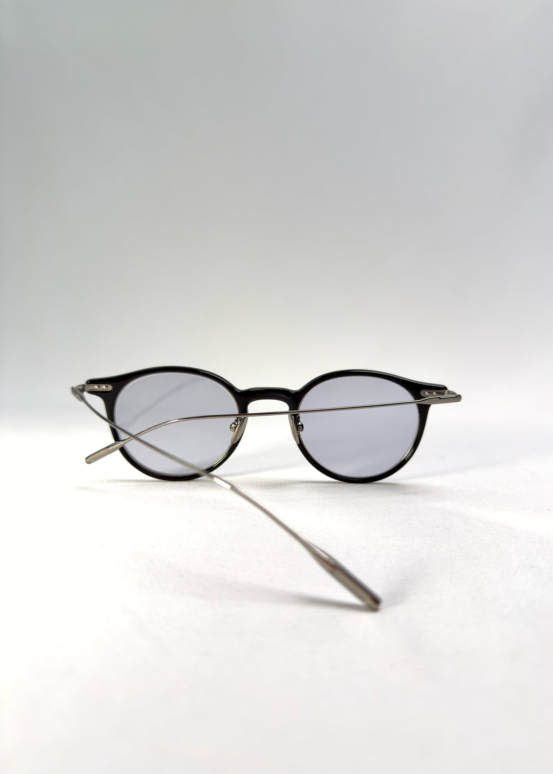 Back-angle view of Lunor Drift Softint sunglasses in Onyx Fade showing the black-to-silver acetate frame and titanium temples. 