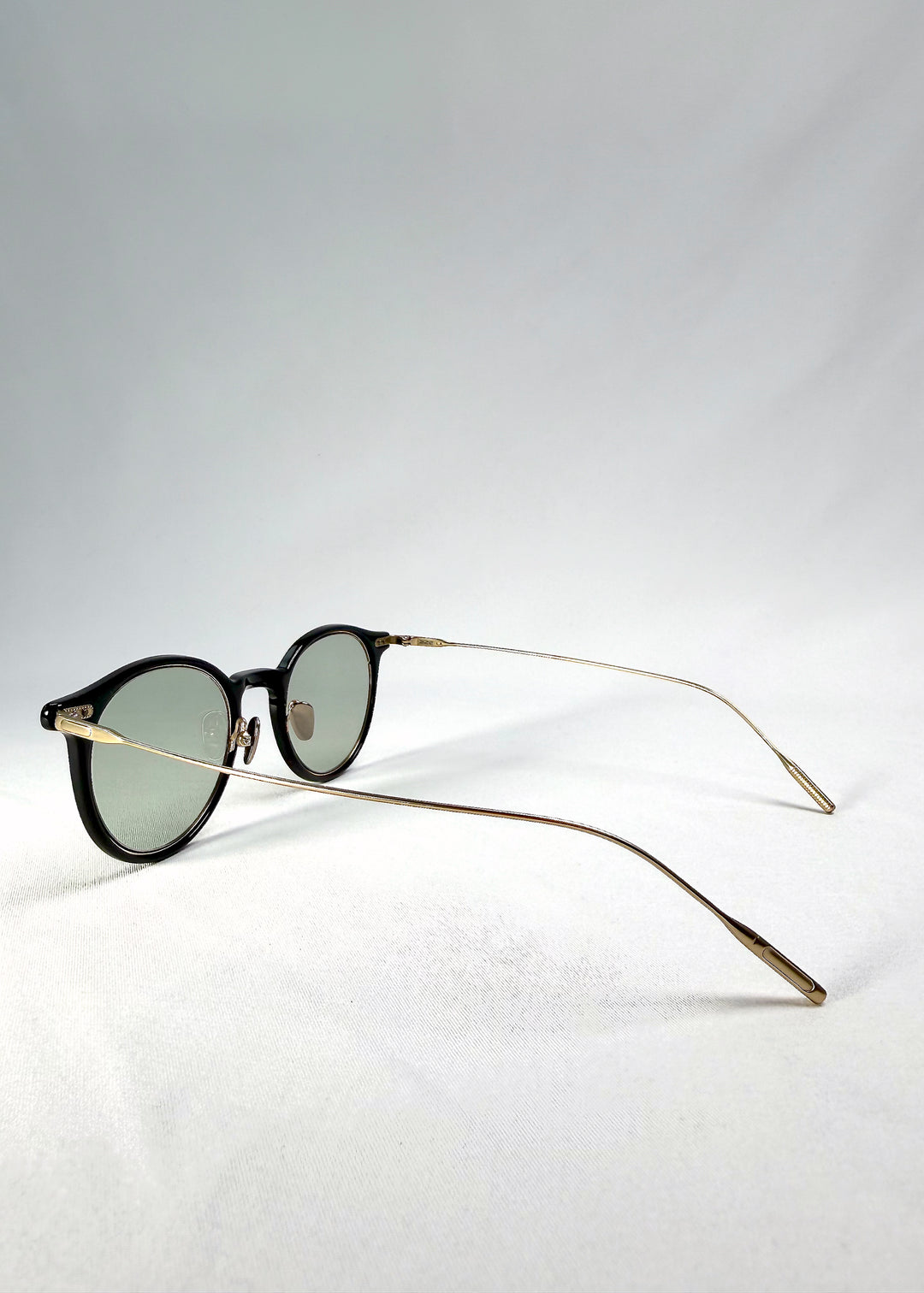 Back-angle view of Lunor Drift Softint sunglasses in Shadow Gleam showing translucent brown frame and gold titanium temples.