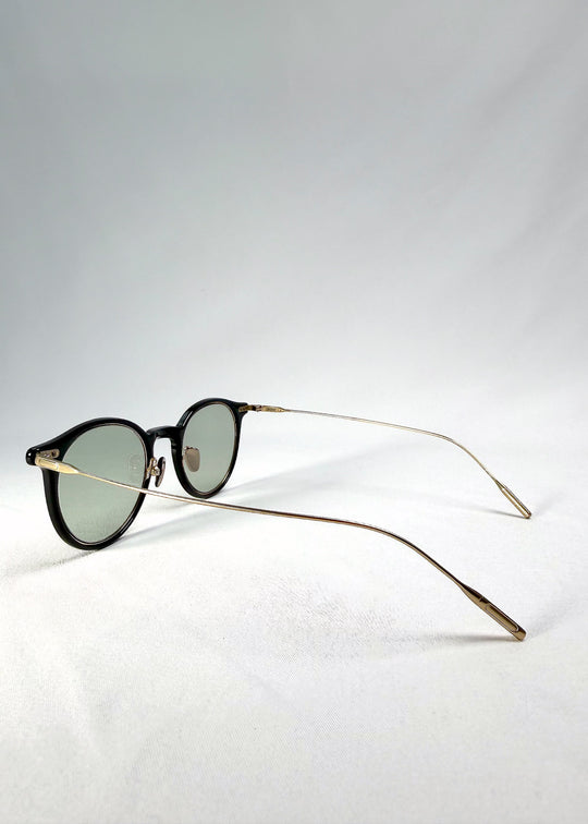 Back-angle view of Lunor Drift Softint sunglasses in Shadow Gleam showing translucent brown frame and gold titanium temples. 