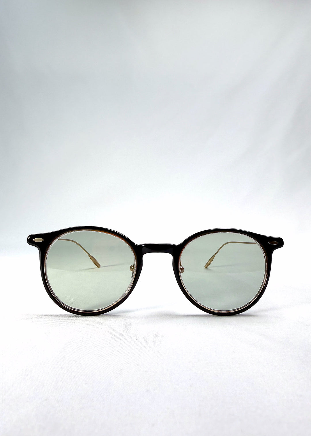 Front view of Lunor Drift Softint sunglasses in Shadow Gleam featuring round hybrid frame and softly tinted green-grey lenses. 