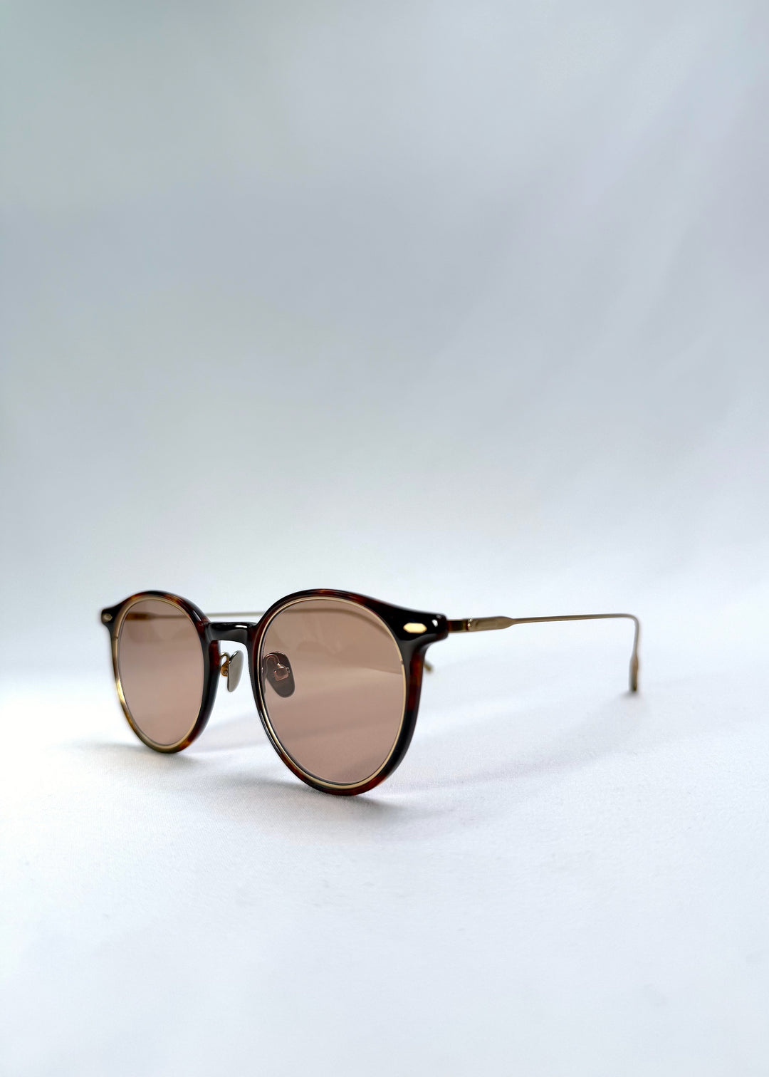 Close-up front-angle view of Lunor Drift Softint sunglasses in Umber Fade showing amber tortoise acetate and gold titanium hinge detail.