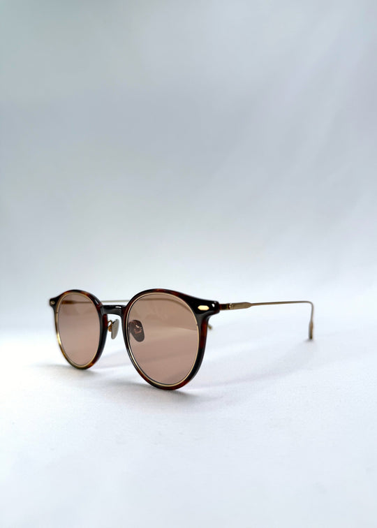 Close-up front-angle view of Lunor Drift Softint sunglasses in Umber Fade showing amber tortoise acetate and gold titanium hinge detail. 