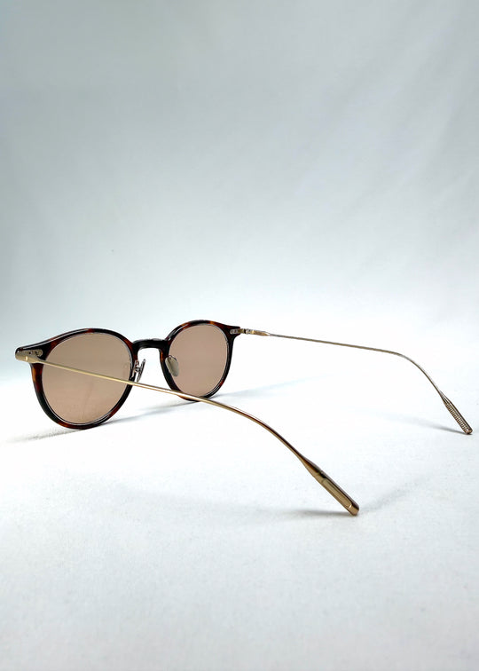 Side-temple view of Lunor Drift Softint sunglasses in Umber Fade showing curved titanium arms and translucent amber frame edges.