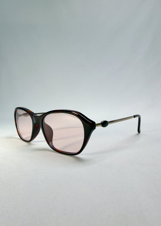 Front-angle view of Ravynor Softint sunglasses in Burnt Amber highlighting rose-tinted lenses and sleek rectangular frame.
