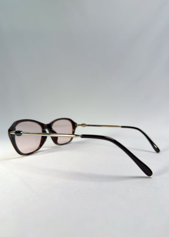 Side-temple view of Ravynor Softint sunglasses in Burnt Amber displaying hybrid frame and silver temple arms. 