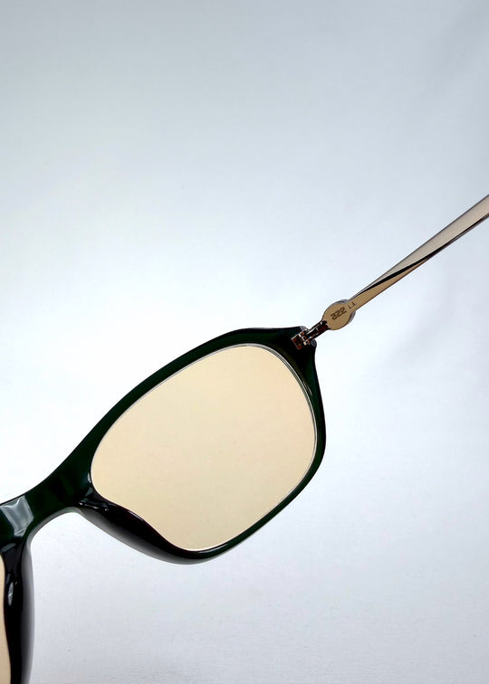 Close-up of Ravynor Softint sunglasses in Jade Shadow showing the hinge and deep green acetate frame. 