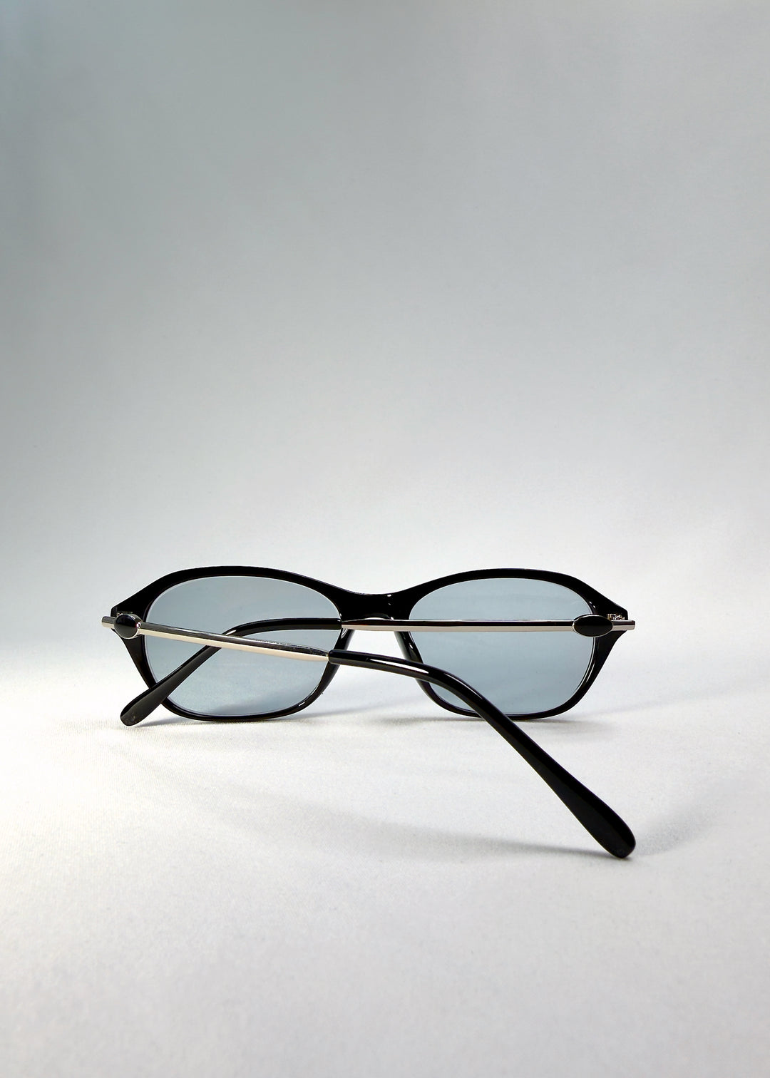 Back-angle view of Ravynor Softint sunglasses in Noir Alloy showing glossy black acetate frame and silver alloy temples.