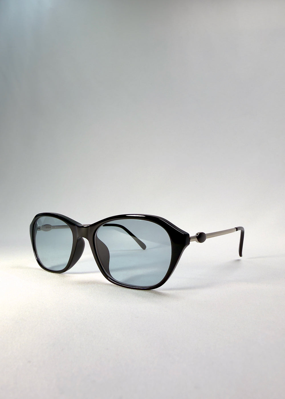 Front-angle view of Ravynor Softint sunglasses in Noir Alloy highlighting cool grey-blue Softint lenses and structured rectangular silhouette.