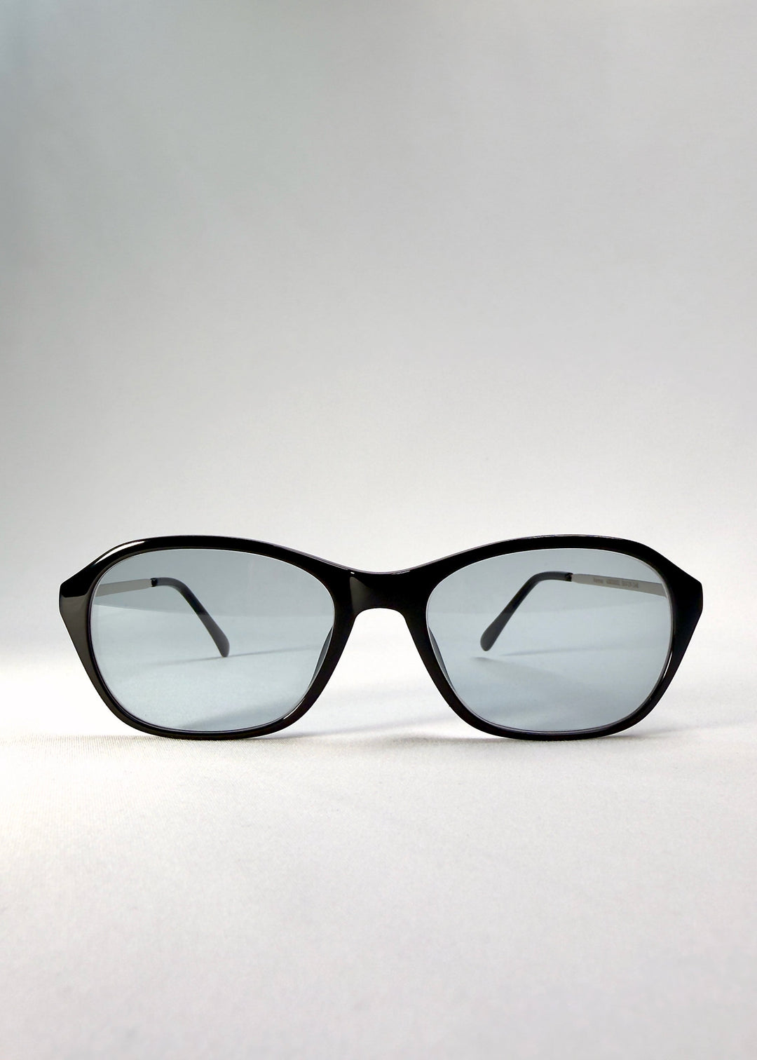 Front view of Ravynor Softint sunglasses in Noir Alloy featuring sharp rectangular frame and reflective grey-blue Softint lenses. 